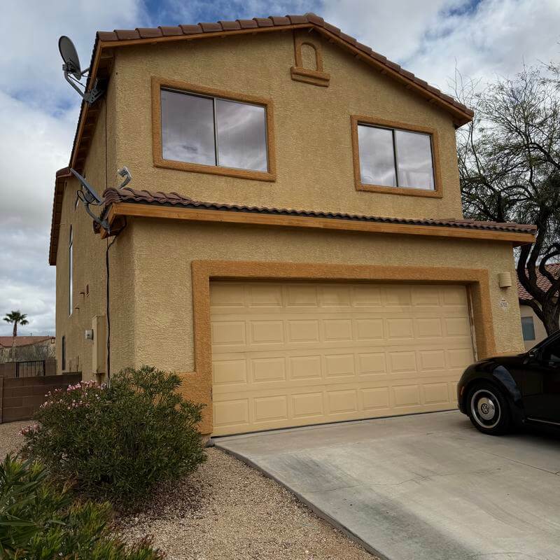 Two-story home with dated tan stucco before restoration