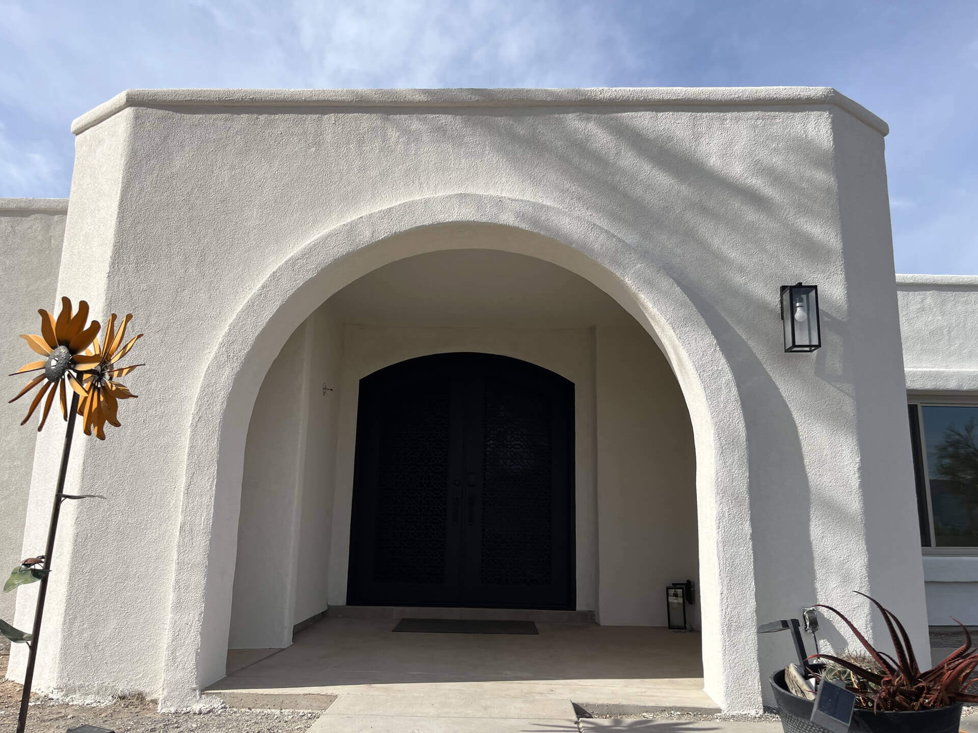 Freshly finished white stucco home with arched entry in Tucson